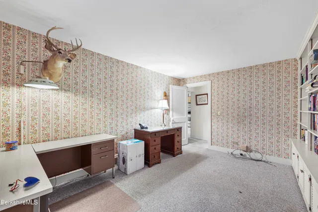 a view of an empty room with fireplace and a window
