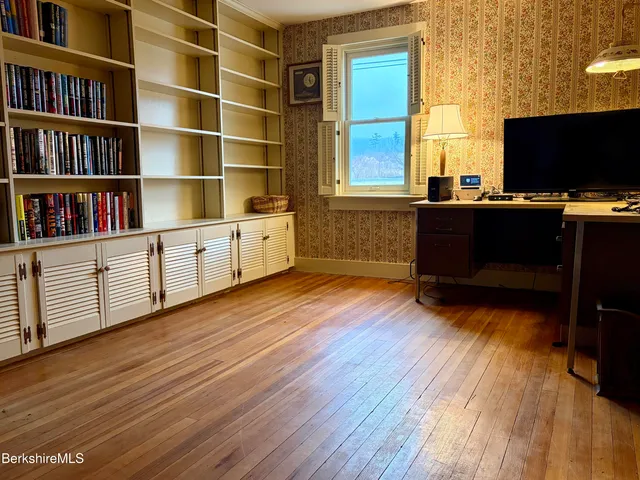 a bedroom with a bed and a painting on the wall