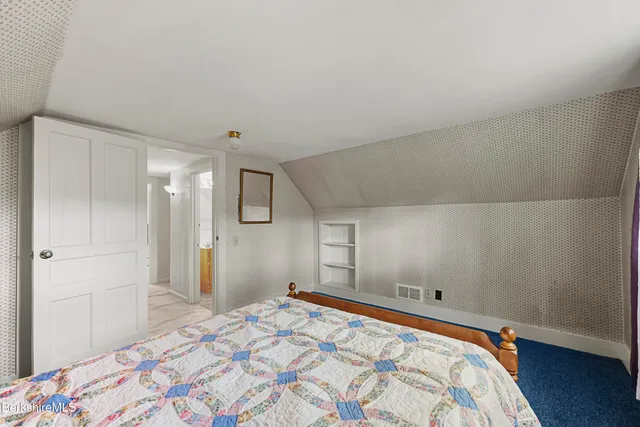 a bedroom with a bed and a painting on the wall