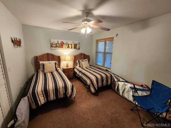 a bedroom with two beds lamp and a dresser