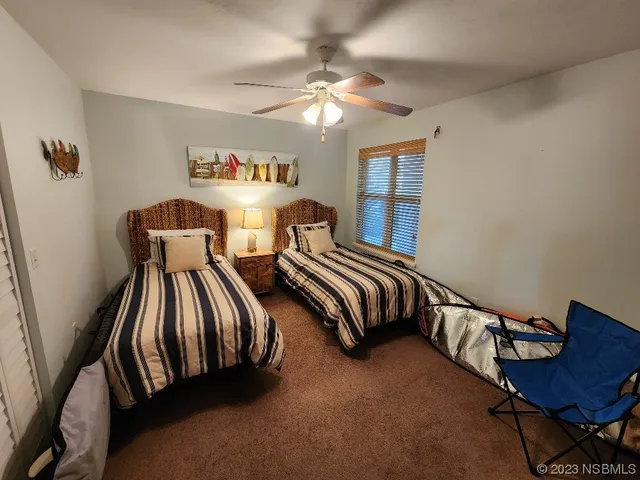 a bedroom with two beds lamp and a dresser