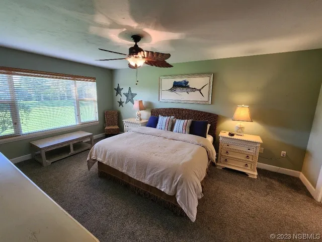 a bedroom with a bed a chandelier and a large window