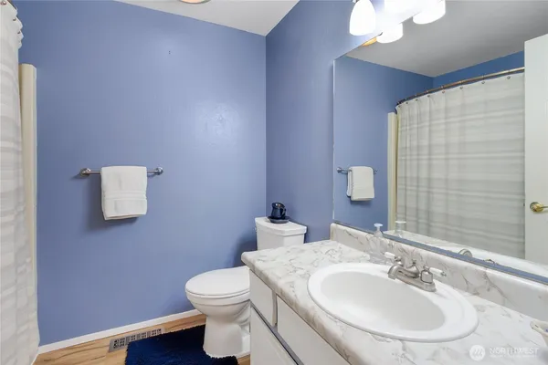 a bathroom with a sink a toilet and mirror