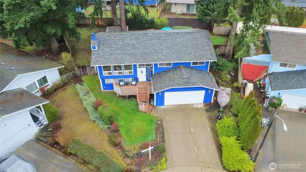 an aerial view of a house with a yard and large trees