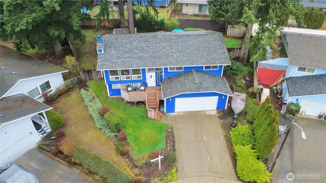 an aerial view of a house with a yard and large trees