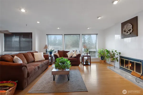 a living room with furniture floor to ceiling window and wooden floor