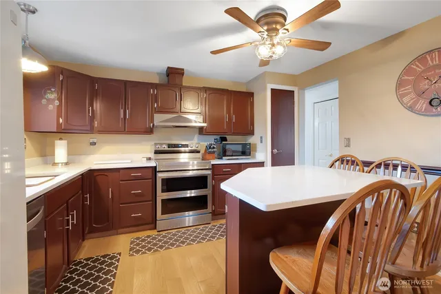 a kitchen with stainless steel appliances granite countertop a stove a sink dishwasher and a refrigerator with cabinets
