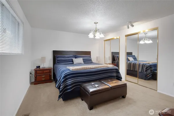 a bedroom with a bed and a chandelier