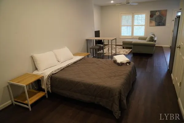 a bedroom with a bed and a couch next to a window