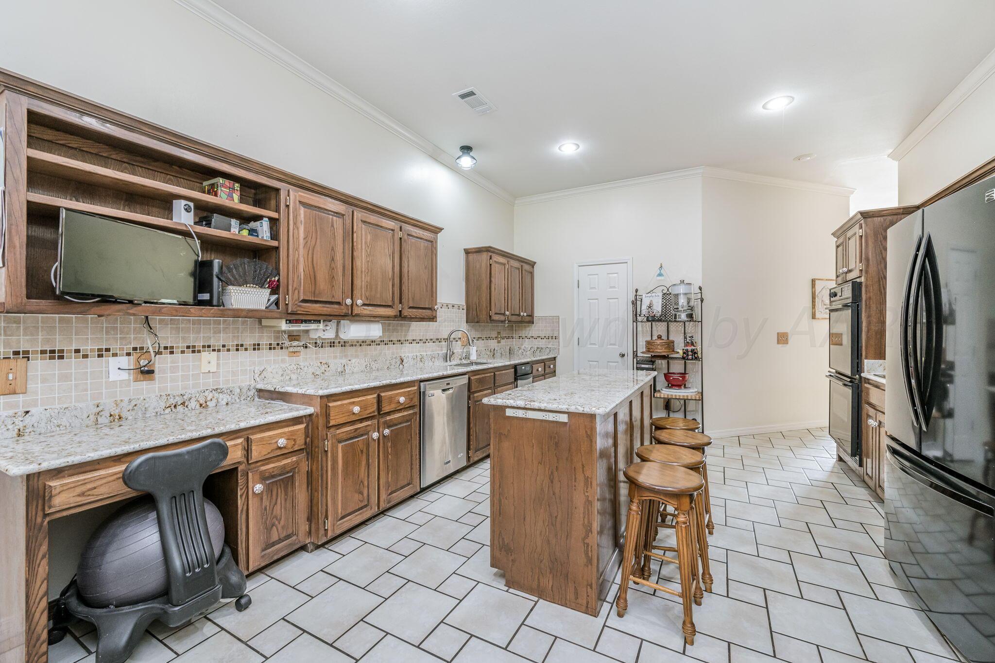 7809 Bent Tree Drive Amarillo, TX 79121 - Photo 7 of 31 a kitchen with stainless steel appliances granite countertop a sink and a refrigerator