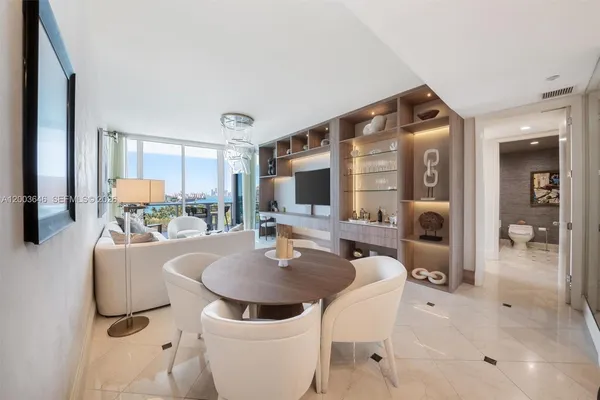 a living room with furniture a flat screen tv and a table