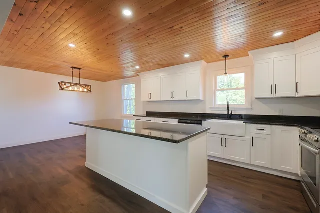 a kitchen with granite countertop a sink and cabinets