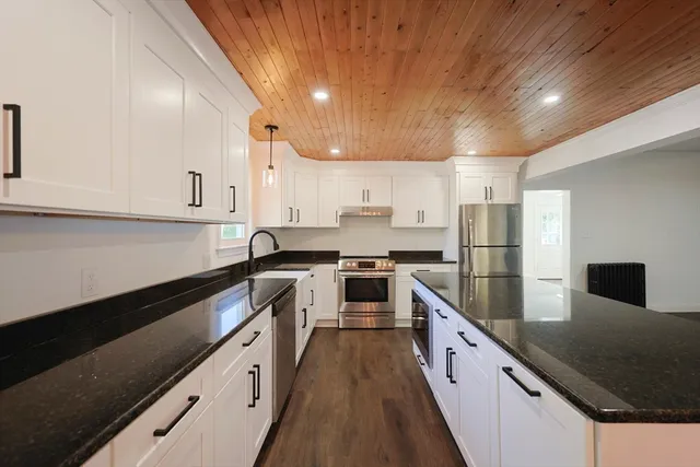 a kitchen with stainless steel appliances granite countertop a sink a stove and a refrigerator