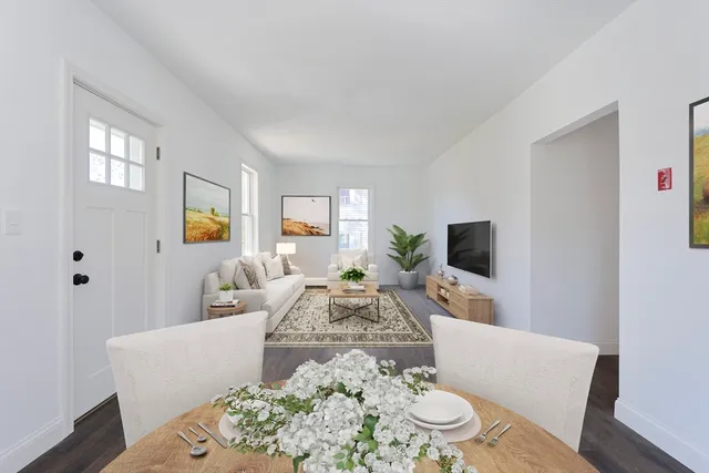 a living room with furniture a flat screen tv and a large window