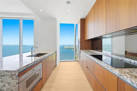 a large kitchen with stainless steel appliances granite countertop a sink and a stove