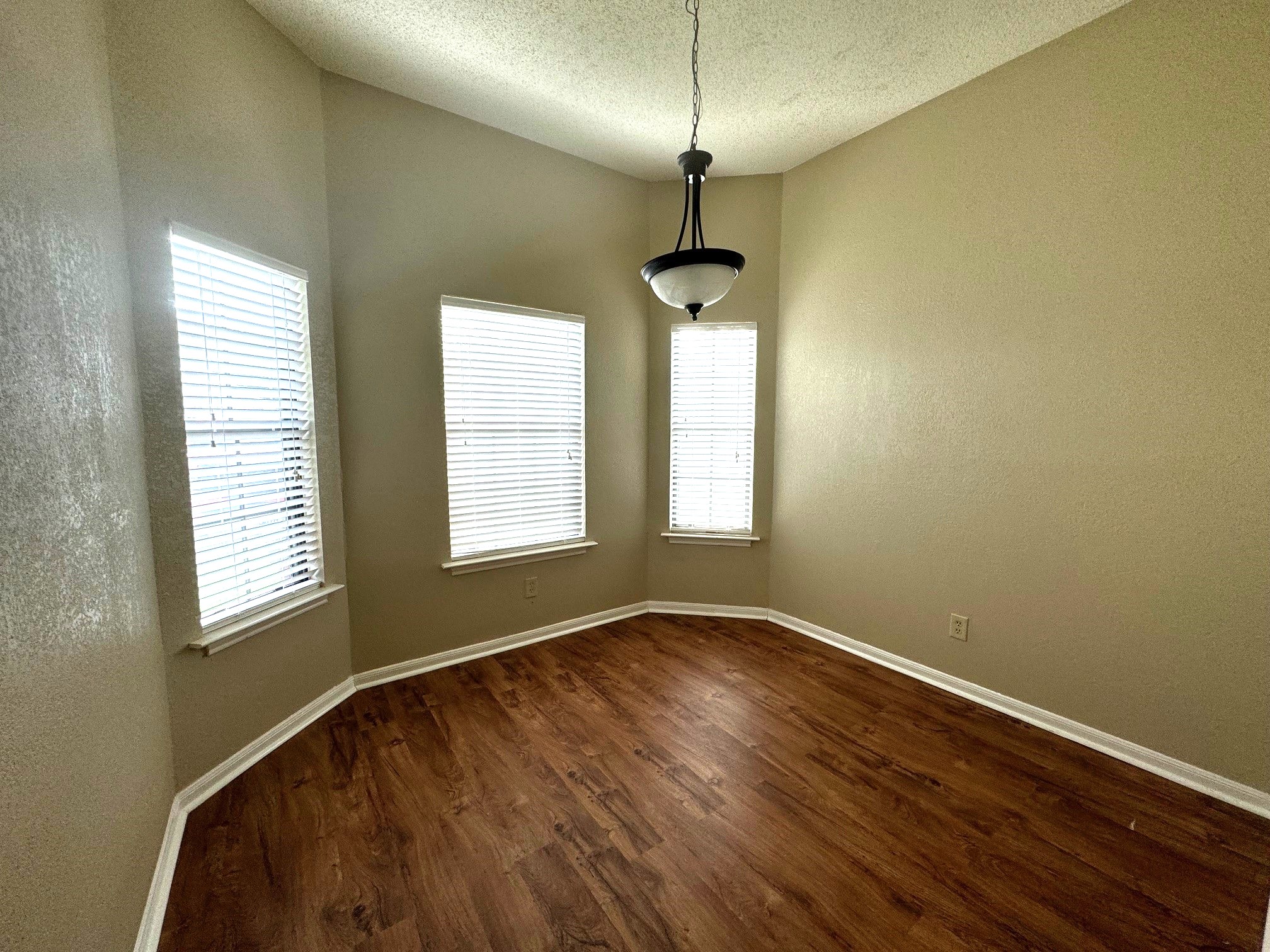 117 Quail Cove, Unit A Lockhart, TX 78644 - Photo 2 of 12 a view of an empty room with a window and wooden floor
