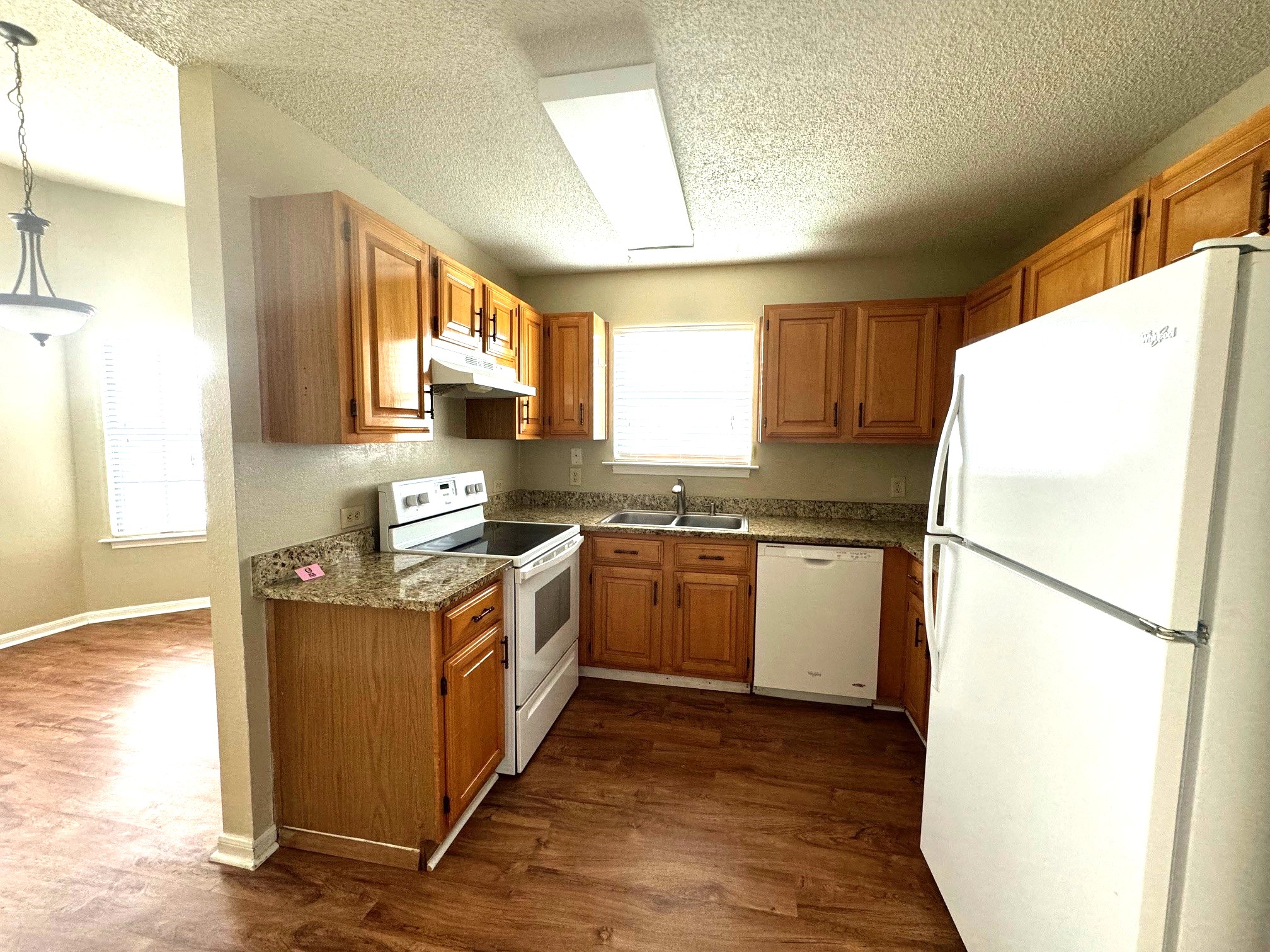 117 Quail Cove, Unit A Lockhart, TX 78644 - Photo 6 of 12 a kitchen with a refrigerator a stove a microwave and cabinets
