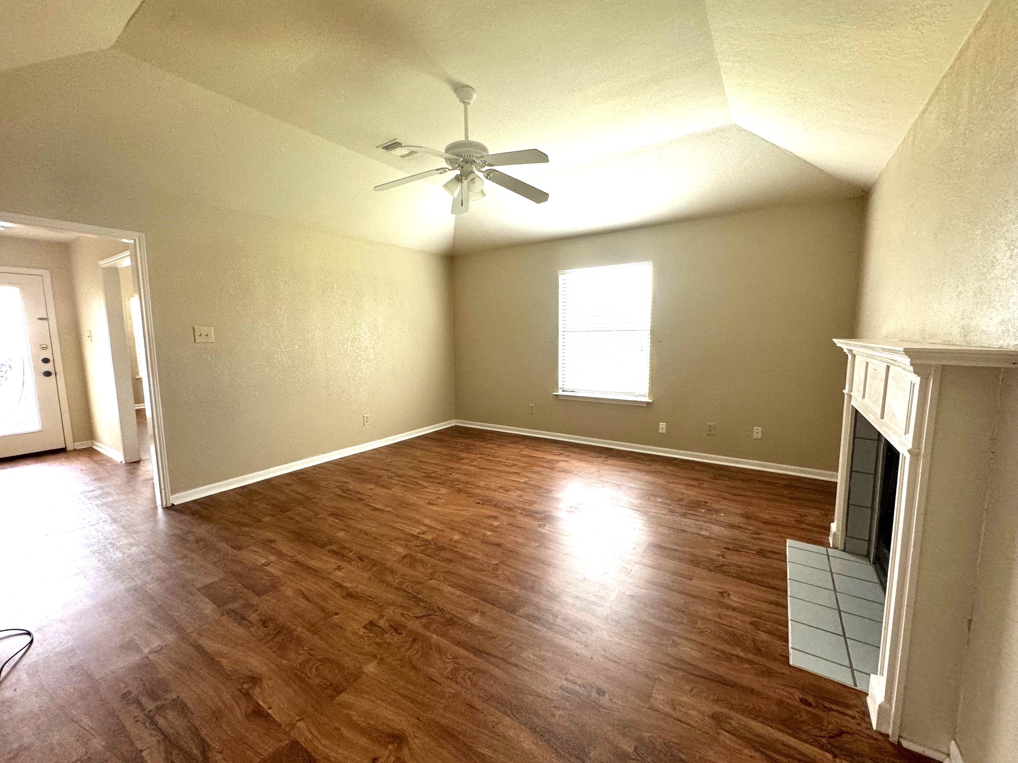 117 Quail Cove, Unit A Lockhart, TX 78644 - Photo 9 of 12 a view of an empty room with wooden floor and a window