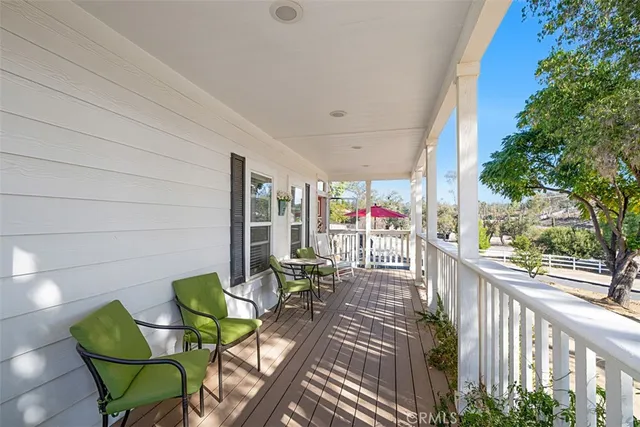 a view of a patio with table and chairs potted plants with wooden floor and fence