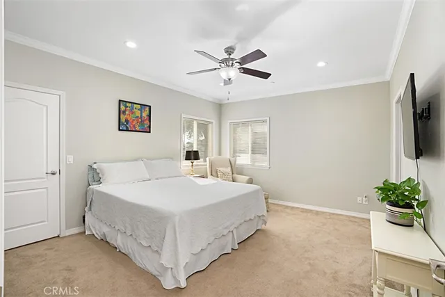 a spacious bedroom with a bed and a flat screen tv