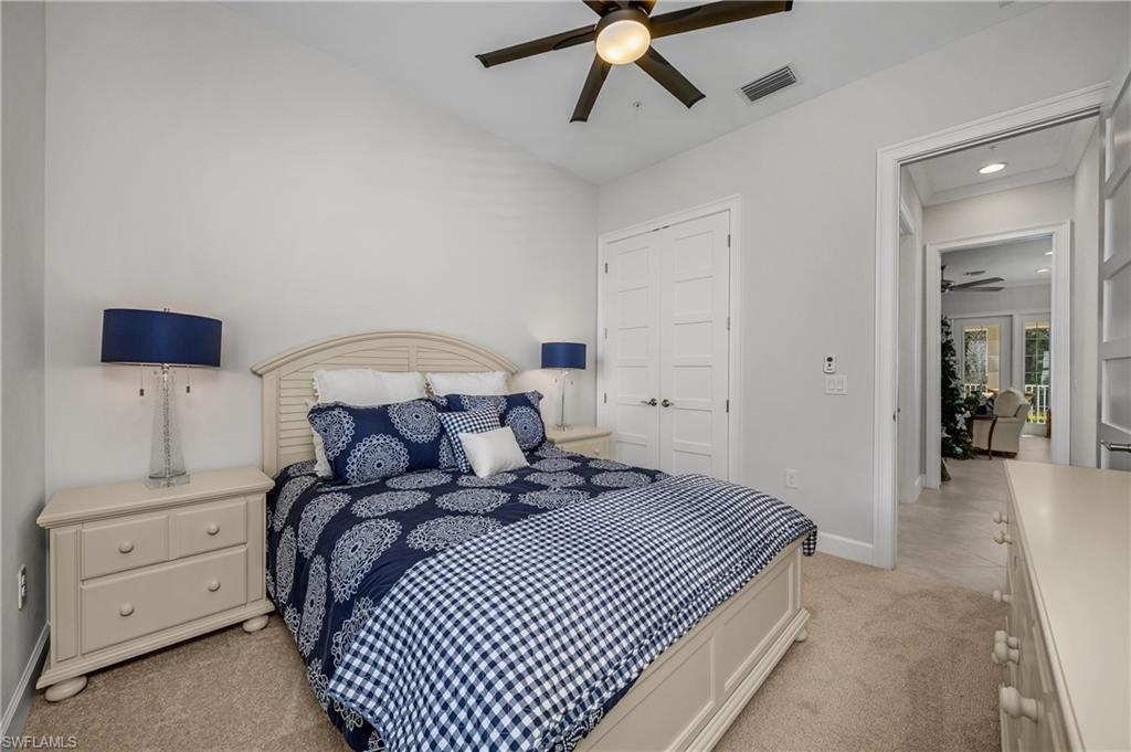 6552 Dominica Drive, Unit 101 Naples, FL 34113 - Photo 20 of 50 a bedroom with a bed and a chandelier