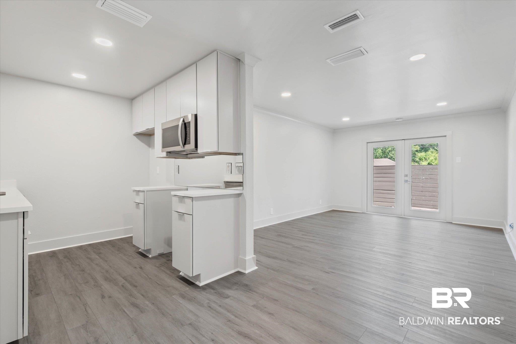 3655 Old Shell Road, Unit 712 Mobile, AL 36608 - Photo 9 of 19 Kitchen with french doors, light countertops, white cabinetry, light wood finished floors, and recessed lighting