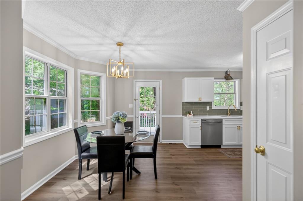 190 Killian Street Canton, GA 30114 - Photo 10 of 44 a dining room with wooden floor a chandelier a wooden table and chairs