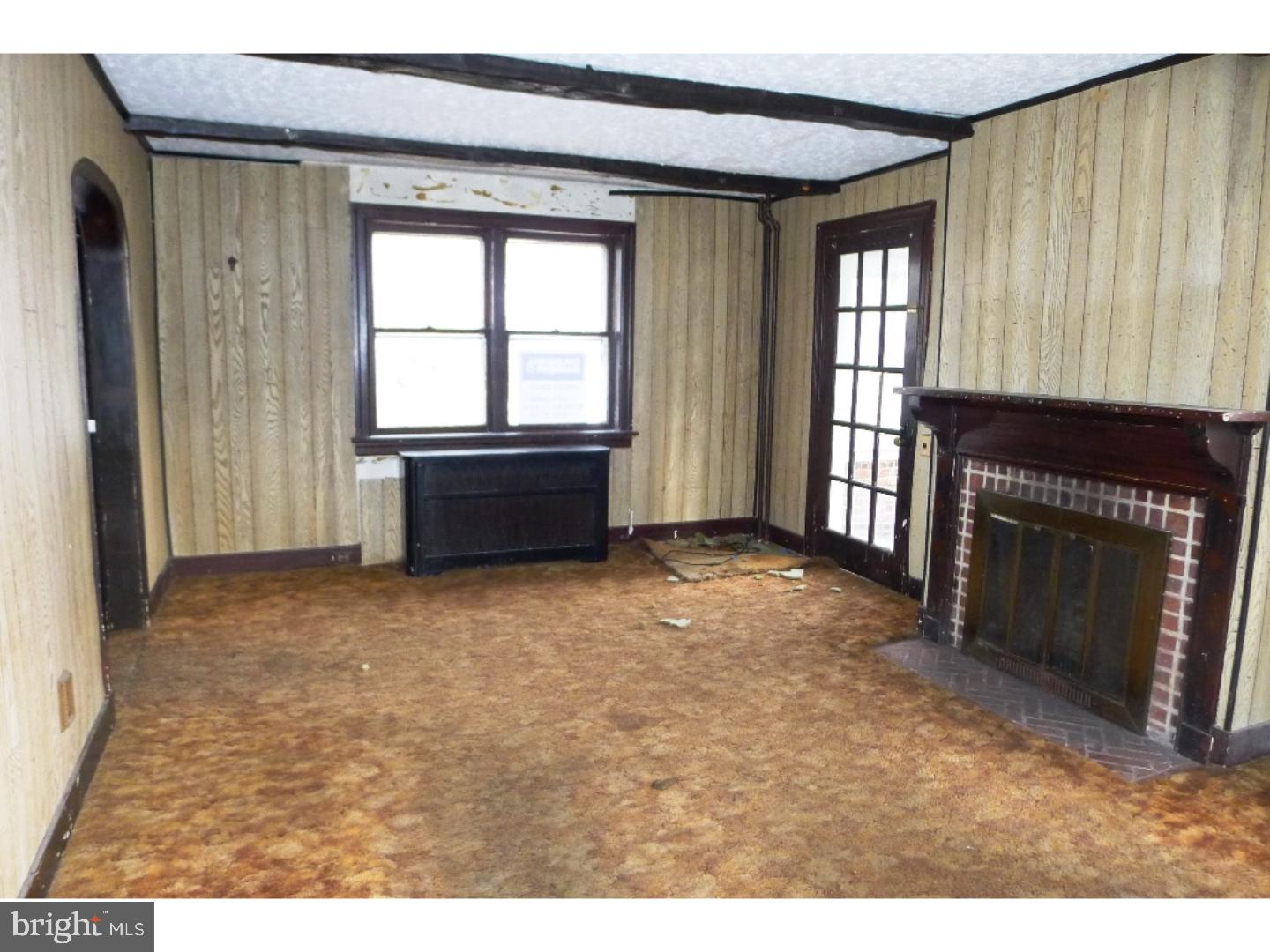 3129 South Atlanta Road Camden, NJ 08104 - Photo 6 of 13 a living room with a fireplace and a large window
