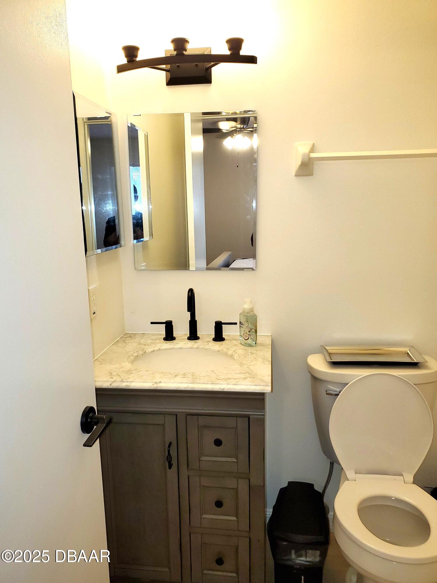 165 White Fawn Drive, Unit MB Daytona Beach, FL 32114 - Photo 31 of 34 a bathroom with a granite countertop toilet sink and mirror