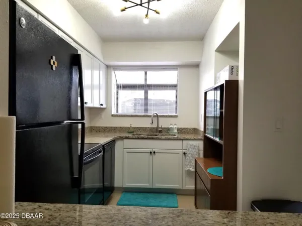 a kitchen with a sink a refrigerator and cabinets