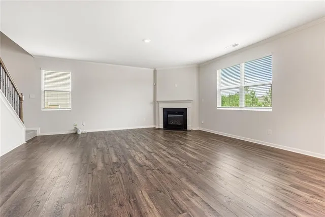 an empty room with windows and a fireplace