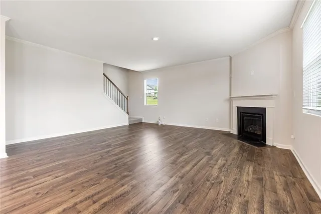 an empty room with wooden floor and fireplace