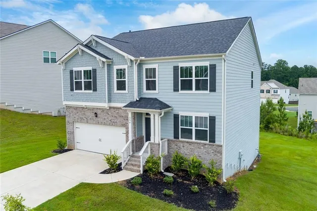 a view of a house with a yard and potted plants