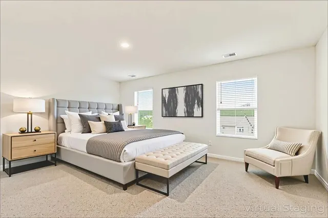 a spacious bedroom with a bed and a couch with window