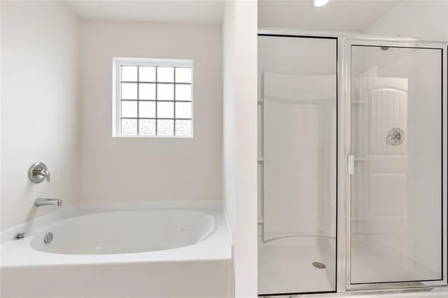 a white bath tub sitting next to a shower