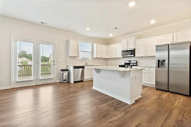 a kitchen with white cabinets and stainless steel appliances