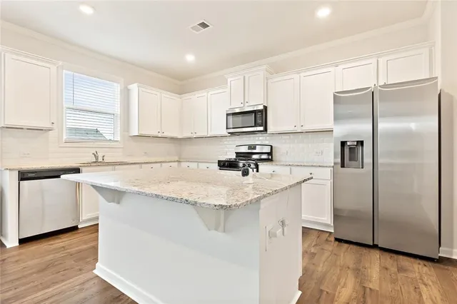 a kitchen with stainless steel appliances granite countertop a refrigerator sink and microwave