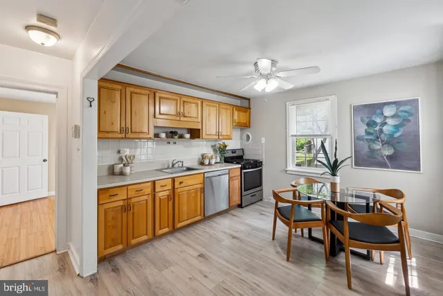 a kitchen with stainless steel appliances granite countertop wooden cabinets a dining table and chairs
