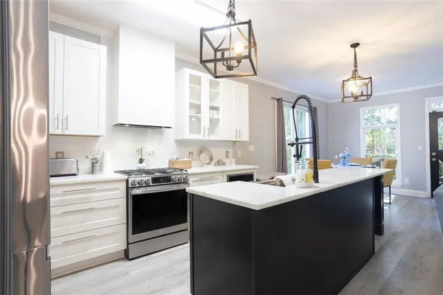 a kitchen with kitchen island granite countertop a sink a stove and cabinets