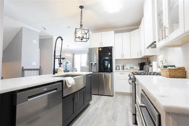 a kitchen with stainless steel appliances kitchen island granite countertop a sink a stove and refrigerator