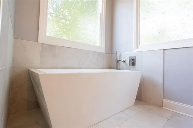 a white tub sitting in a bathroom next to a window