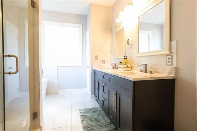 a bathroom with a double vanity sink a mirror and a shower