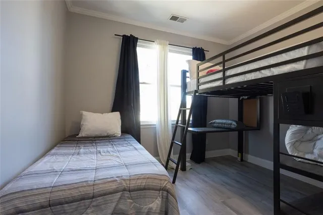 a bedroom with a bed and wooden floor