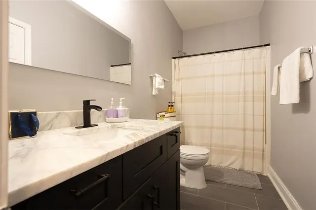 a bathroom with a sink a toilet and shower curtain
