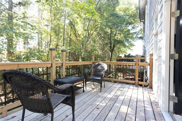 a view of deck with furniture and trees in the background