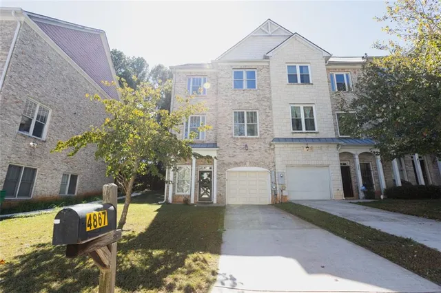 a view of a white house with a yard and plants
