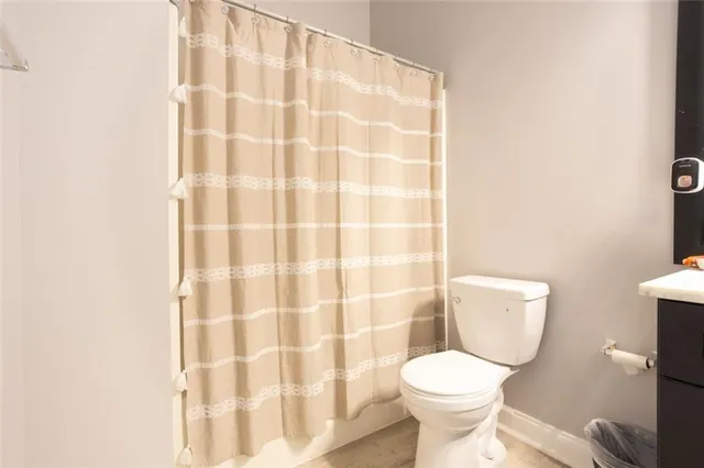 a white toilet sitting next to a shower curtain