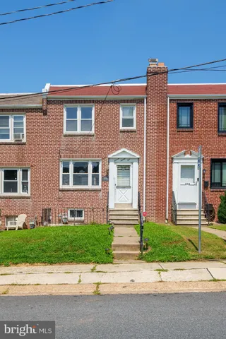 a front view of a house with a garden and plants