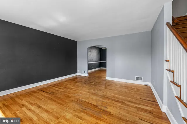 a view of empty room with wooden floor