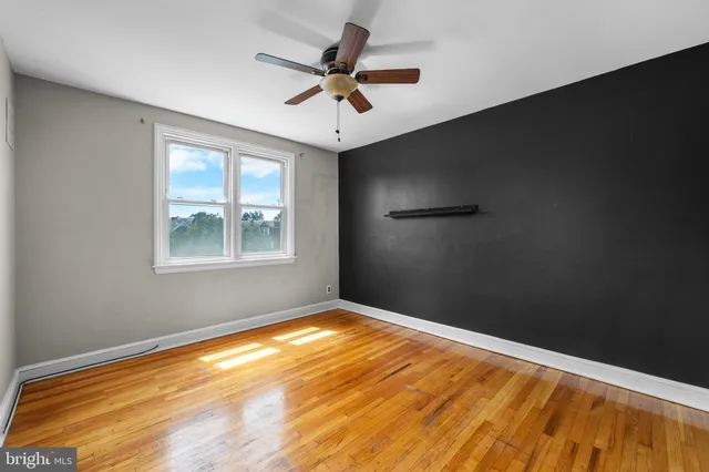 a view of a big room with wooden floor and windows